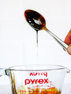 a spoon dipped in balsamic reduction over the pyrex