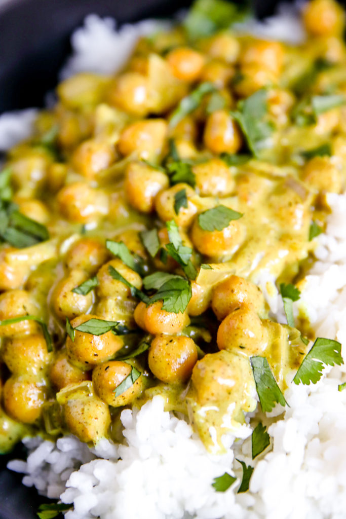 a close up of chickpea coconut curry with cilantro on top