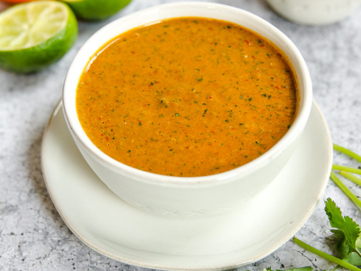 a bowl of chipotle lime sauce on a plate with ingredients around it