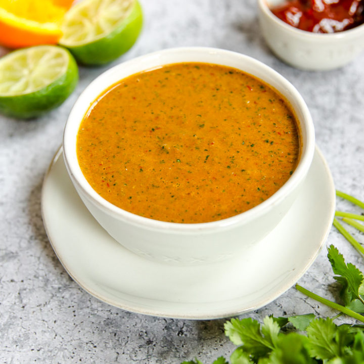 a bowl of chipotle lime sauce on a plate with ingredients around it