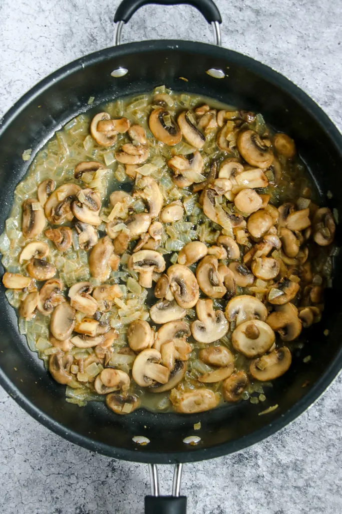 a skillet of mushrooms, onions, and white wine