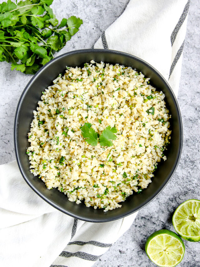 a black bowl on a striped napkin with cilantro lime cauliflower rice in it