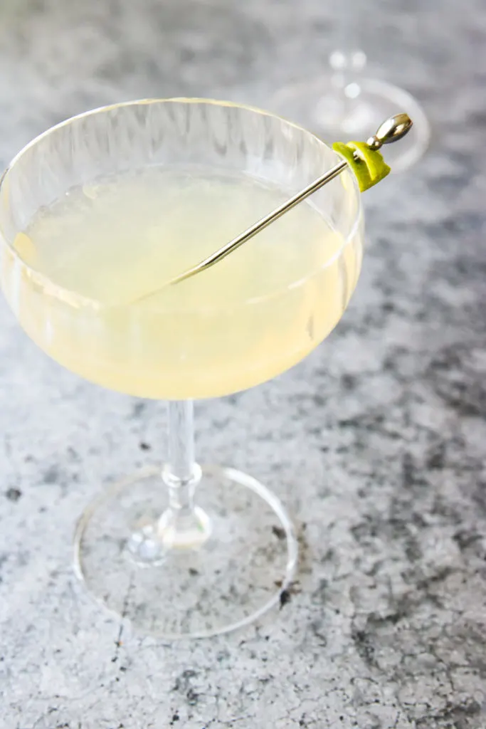 pastel yellow elderflower gimlet in a coupe glass