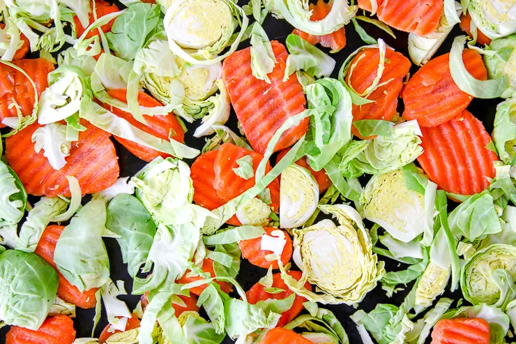 a close up of raw shaved brussels sprouts and ridged carrot chips