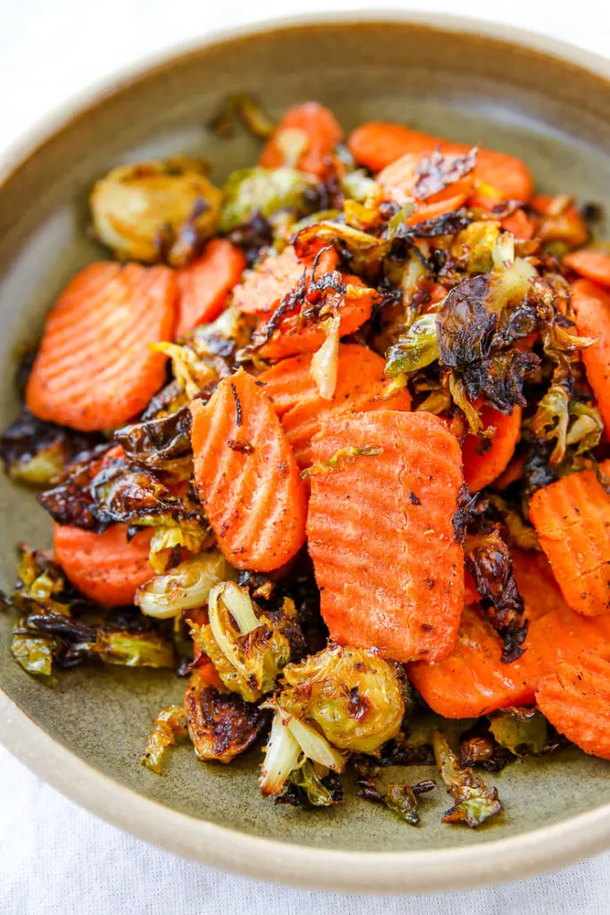 a close up of roasted shaved brussels sprouts and ridged carrot chips