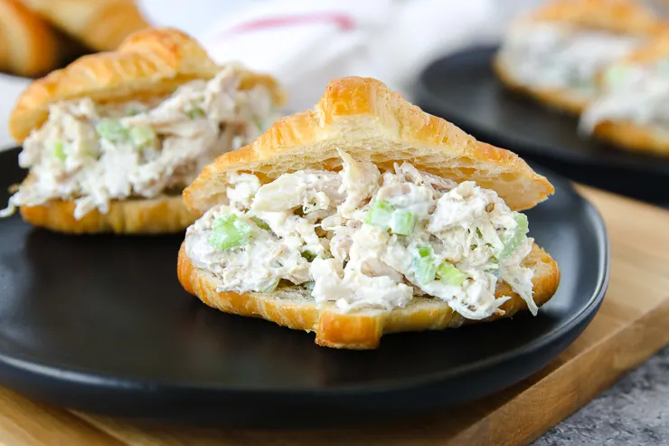 a close up of rotisserie chicken salad in a croissant