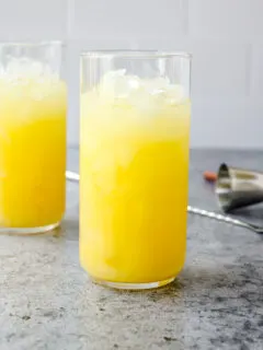 a highball glass full of crushed ice and a screwdriver