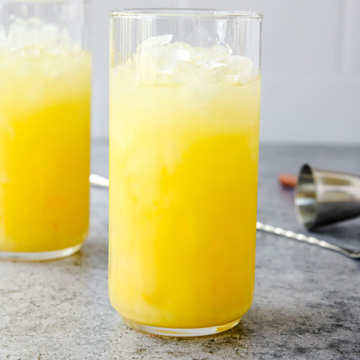 a highball glass full of crushed ice and a screwdriver