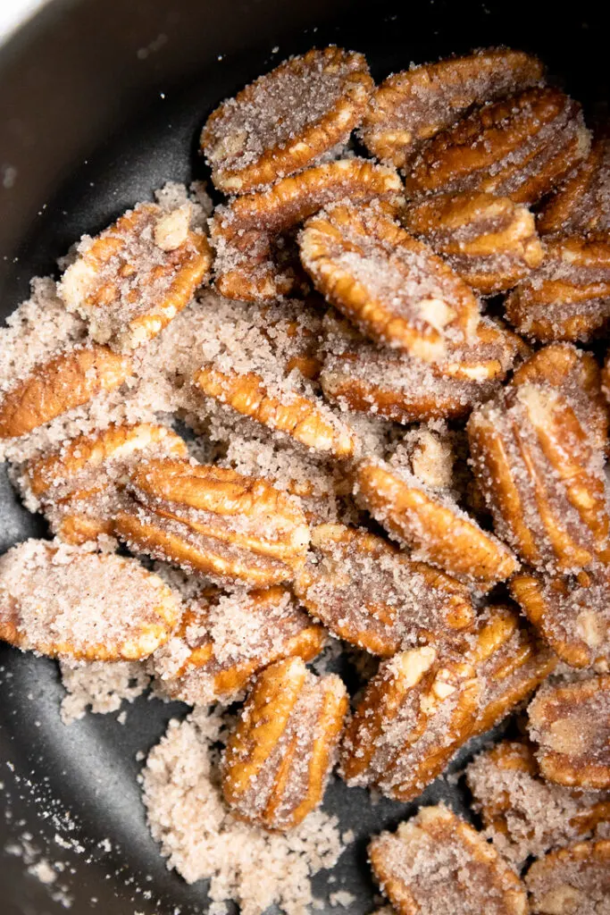 a small saucepan with pecan halves and sugar