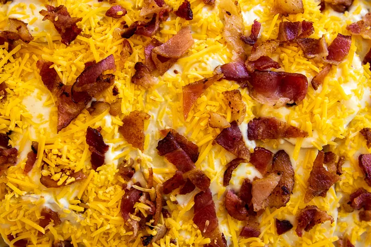 a close up of crumbled bacon on shredded cheese