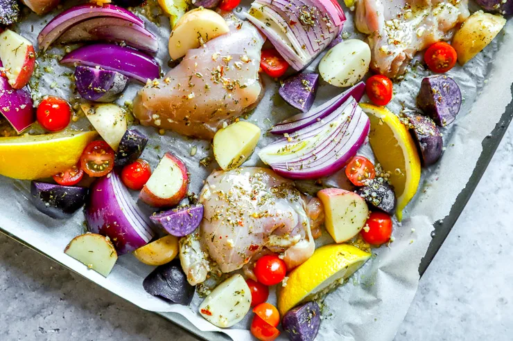 a close up of raw chicken thighs and vegetables covered in marinade