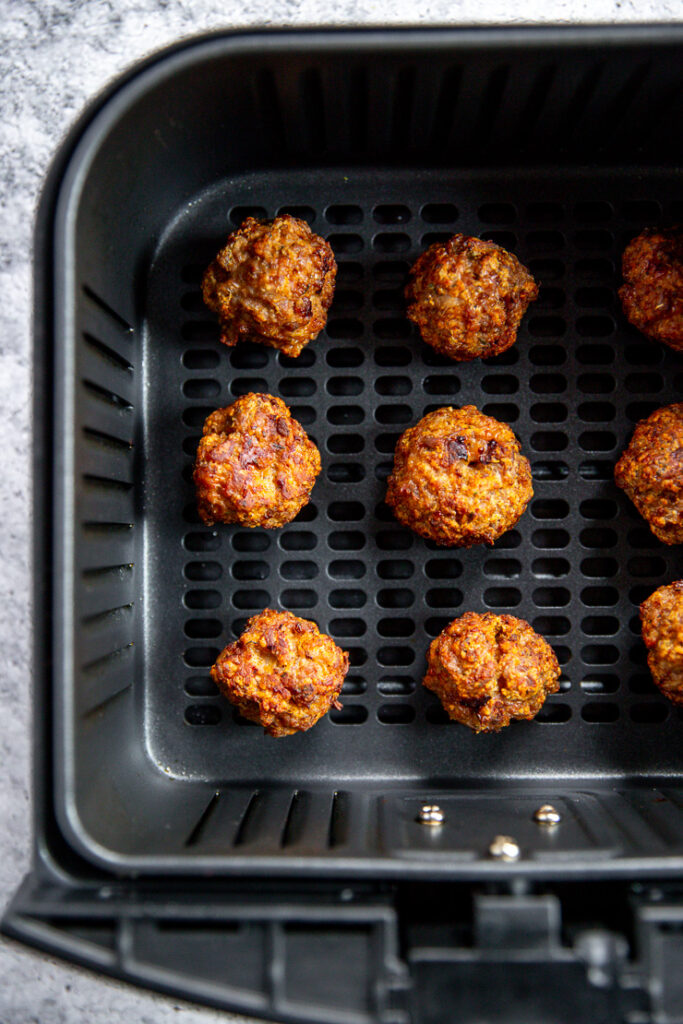 9 cooked turkey meatballs in an air fryer basket