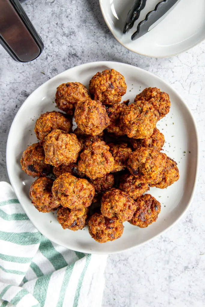 an overhead shot of a plate of air fryer turkey meatballs and a white and green napkin