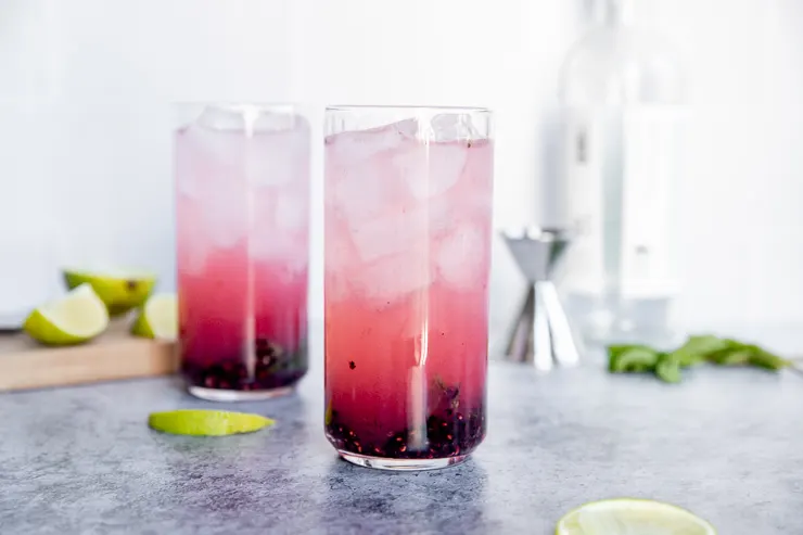 two highball glasses of light pink blackberry mojitos