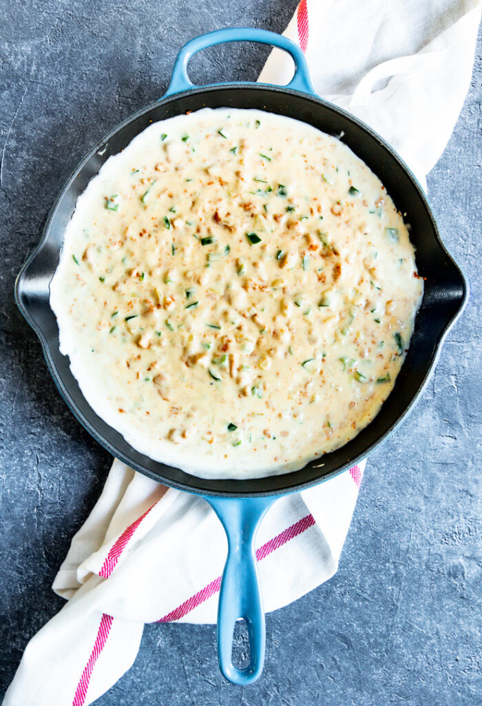 a blue pan with yellow chorizo cheese dip