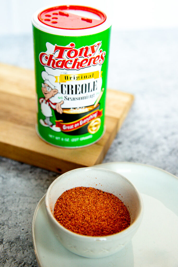 a close up image of a Tony Chachere's Creole Seasoning container and some poured out into a small bowl