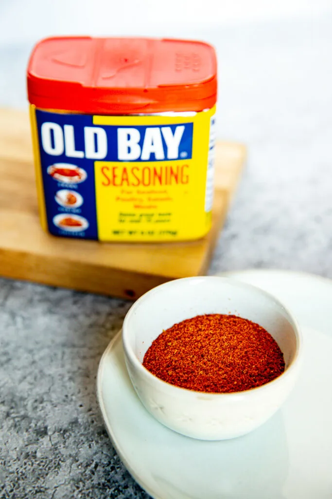 a container of old bay behind some poured into a small bowl