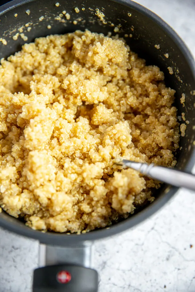 a small pot full of fluffed quinoa and a fork