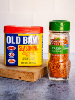 a container of old bay seasoning next to a container of cajun seasoning