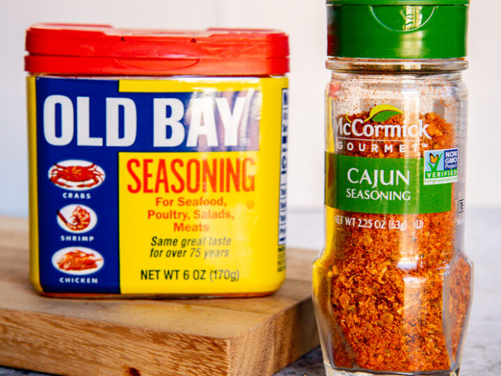 a container of old bay seasoning next to a container of cajun seasoning