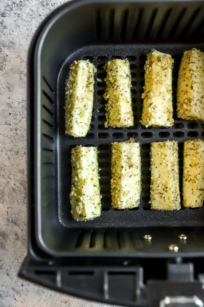 battered air fryer zucchini fries in an air fryer basket