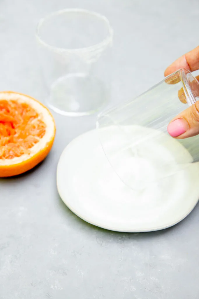 a rocks glass getting rolled into salt on the rim