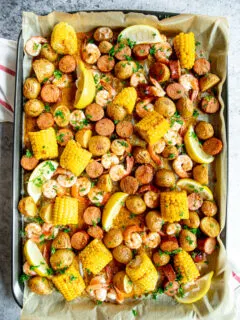 baked sheet pan shrimp boil with lemon slices and chopped parsley