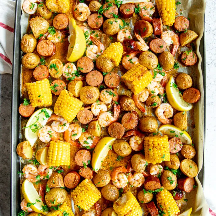 baked sheet pan shrimp boil with lemon slices and chopped parsley