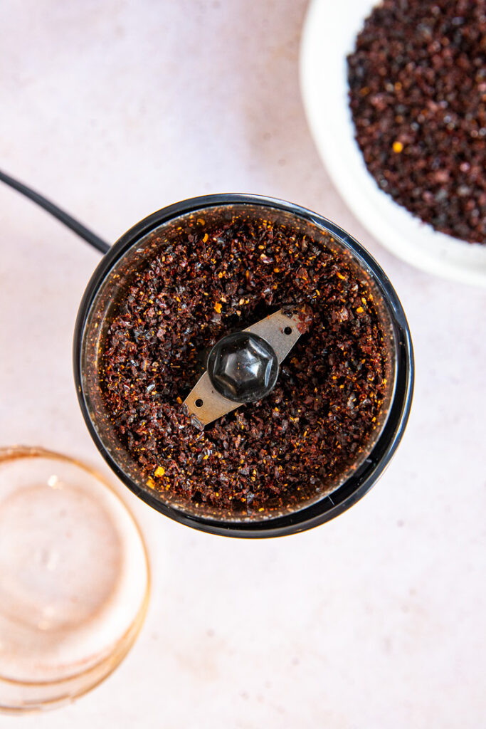 A spice grinder with blended ancho chile powder.