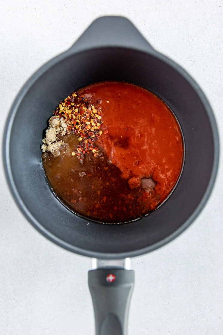 A small sauce pan with firecracker sauce ingredients mixed together.