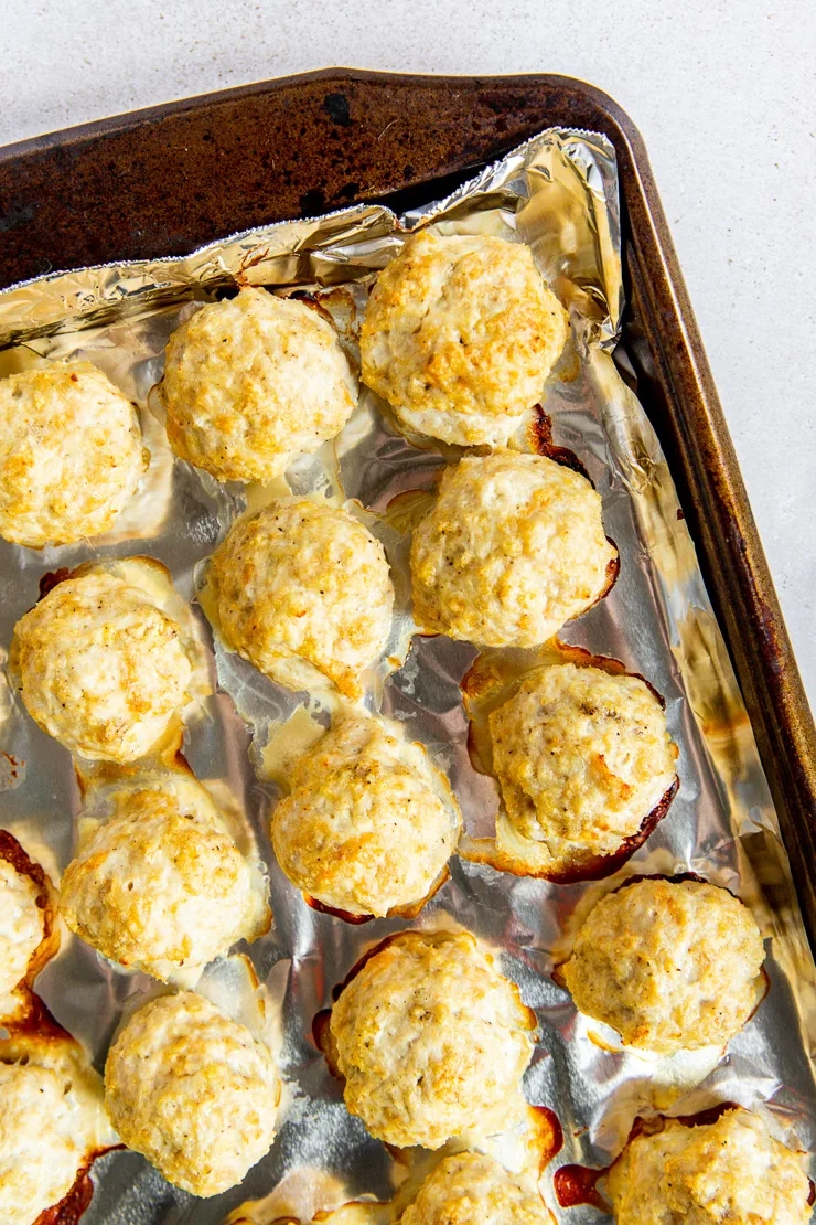 A corner of the cookie sheet is holding baked firecracker meatballs.