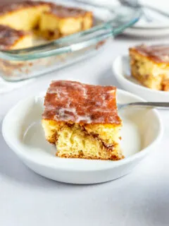 A front on shot of a slice of honey bun cake with a cinnamon swirl running through the middle.