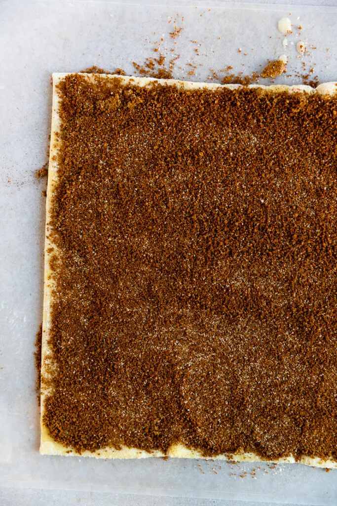 A sheet of puff pastry rolled out with cinnamon sugar spread all over.