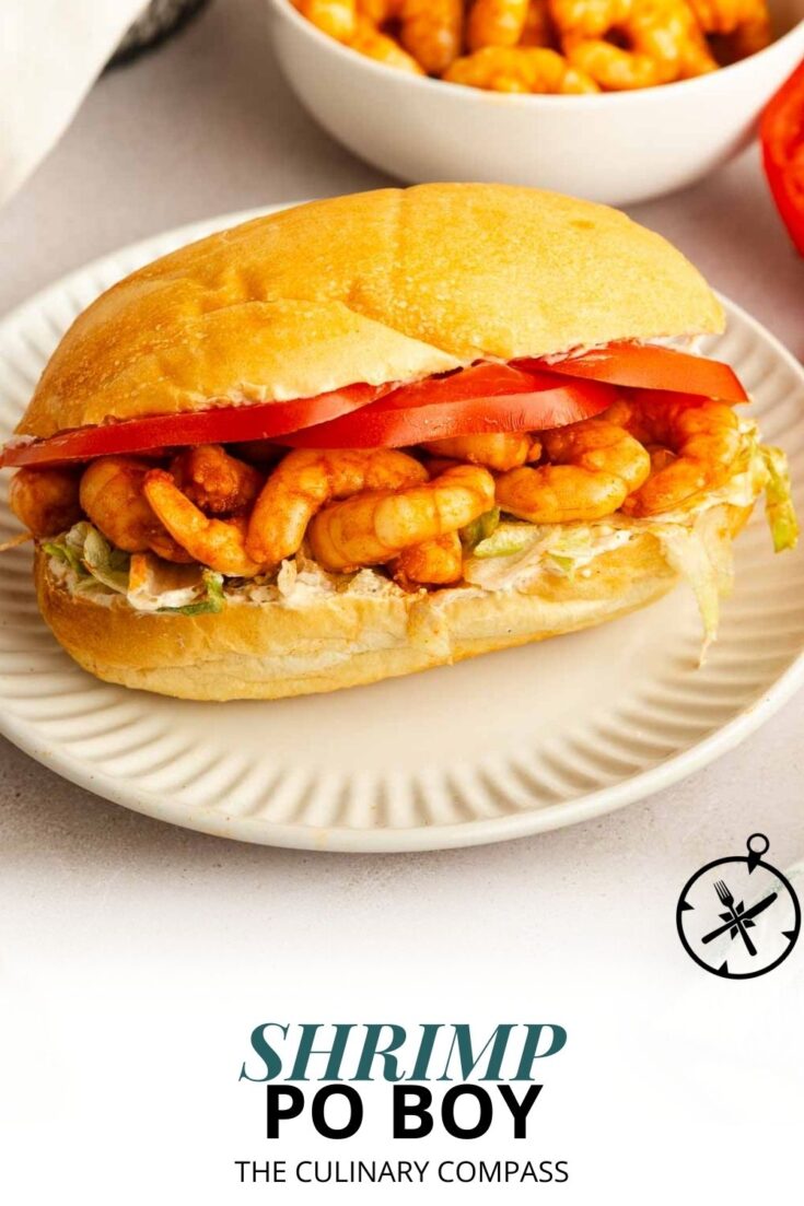 A shrimp po boy sandwich on a white plate, filled with fried shrimp, lettuce, tomato slices, and sauce, with the text Shrimp Po Boy - The Culinary Compass at the bottom.